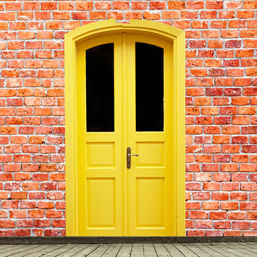 Yellow door on a brick wall